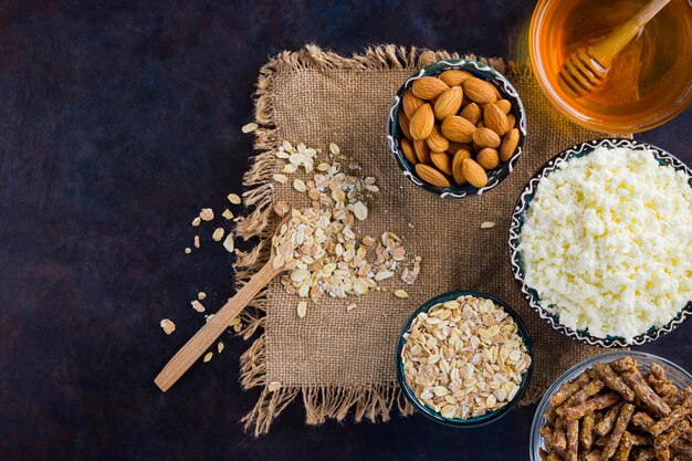 Desayuno de dieta saludable en burlap Ingredientes para un desayuno saludable harina de avena granola miel