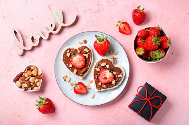 Foto desayuno para dos comida de día de san valentín para una pareja enamorada con tostadas de chocolate y fresa