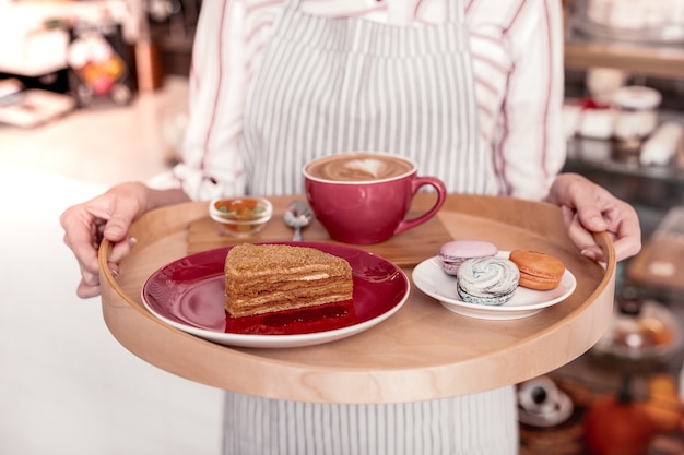 Desayuno dulce. Cerca de un delicioso pastel y sabrosos macarrones de pie en la bandeja