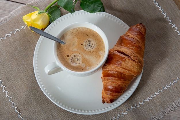 Desayuno francés, café con leche y croissants.