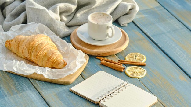 Desayuno francés con croissants y café sobre fondo de madera.