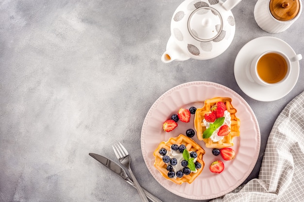 Desayuno con gofres belgas sobre arándanos y fresa