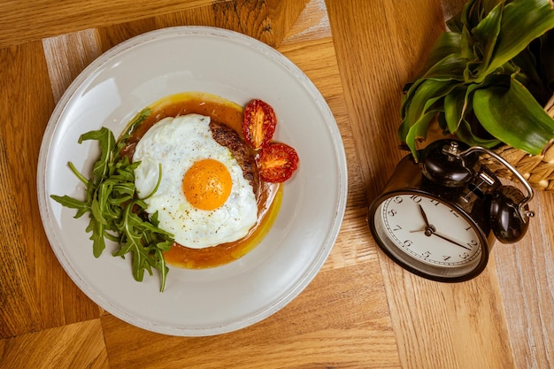 Desayuno huevos fritos con rúcula de bistec y tomate seco