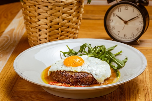 Desayuno huevos fritos con rúcula de bistec y tomate seco