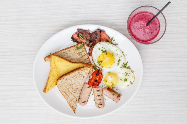 Desayuno con huevos fritos tocino muesli croissants y jugo