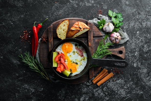 Desayuno Huevos fritos con tocino y verduras en una sartén Vista superior Espacio de copia libre