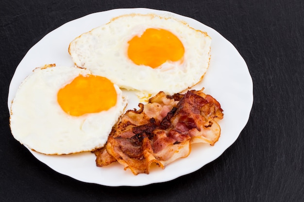 Desayuno con huevos fritos y tocino.