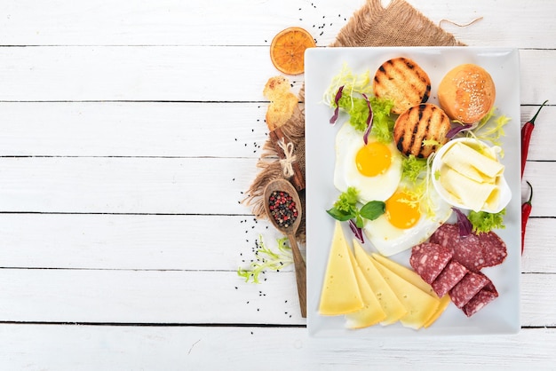 Desayuno Huevos con tocino y tomates pan tostado Vista superior Sobre un fondo de madera Espacio de copia