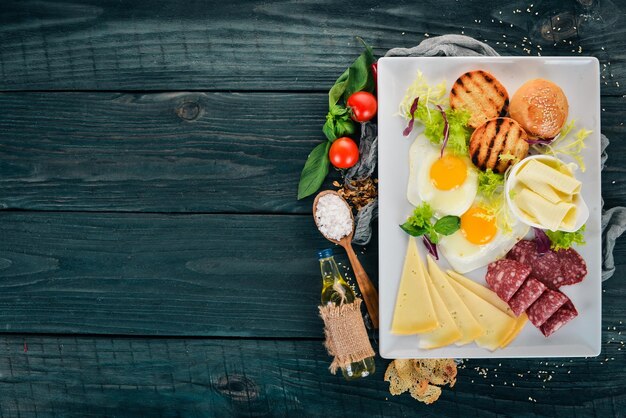 Desayuno Huevos con tocino y tomates pan tostado Vista superior Sobre un fondo de madera Espacio de copia