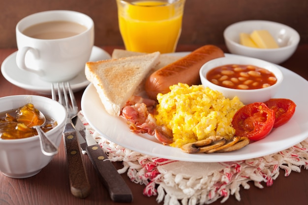 Desayuno inglés completo con huevos revueltos, tocino, salchichas, frijoles, tomate.