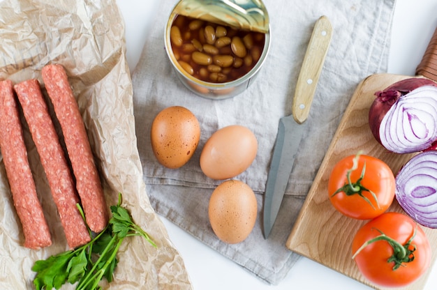 Desayuno inglés en el fondo blanco, ingredientes para cocinar.