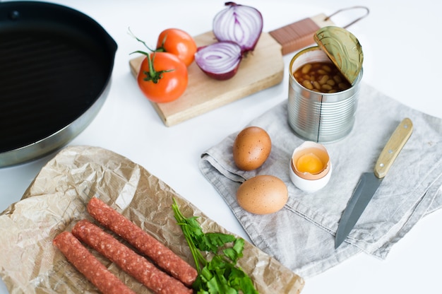 Desayuno inglés en el fondo blanco, ingredientes para cocinar.