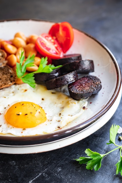 desayuno inglés huevo frito morcilla fresca morcilla pan de cereales frijoles tocino huevos revueltos