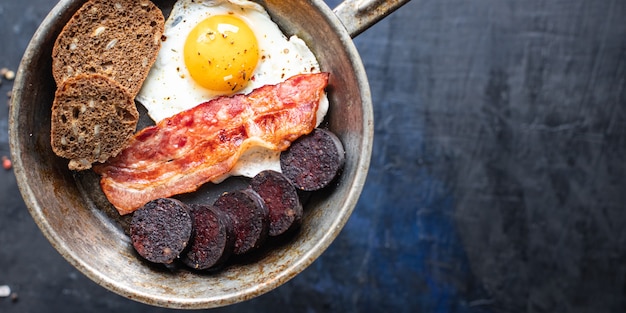 desayuno inglés huevo frito morcilla fresca morcilla pan de cereales frijoles tocino huevos revueltos