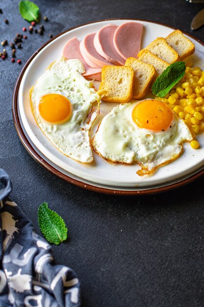 Desayuno inglés huevo frito pan tostado verduras maíz queso y más listo para comer en la mesa