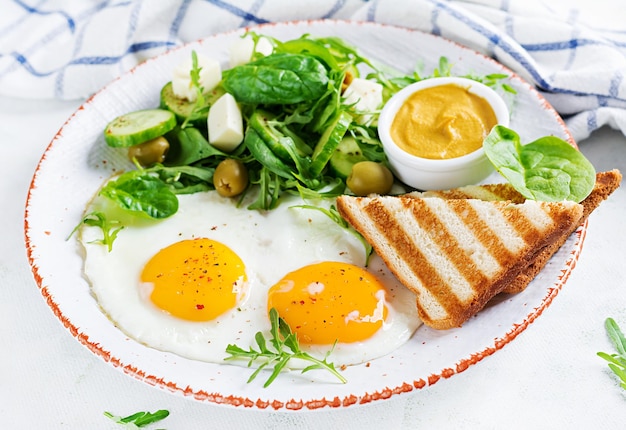 Foto desayuno inglés huevos fritos queso pepino aceitunas y espinacas comida americana