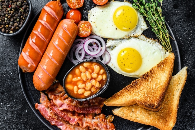 Desayuno inglés con huevos fritos, salchichas, tocino, frijoles y tostadas en un plato