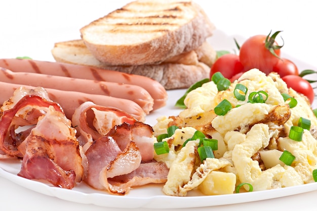Desayuno inglés: huevos revueltos, tocino, salchichas y tostadas