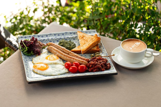 Desayuno inglés servido con café capuchino.