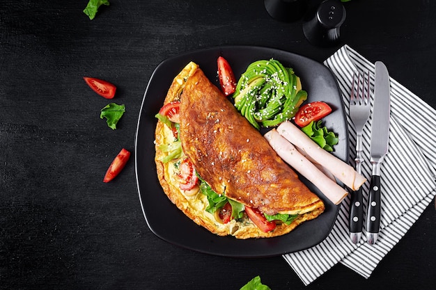 Desayuno keto Tortilla tomate aceitunas y aguacate jamón Dieta cetogénica Desayuno bajo en carbohidratos alto en grasas Concepto de comida saludable Vista superior