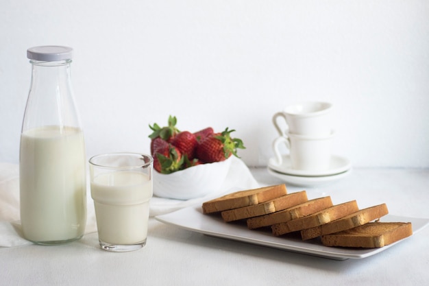 Desayuno con leche fresca, tostadas y fresas.