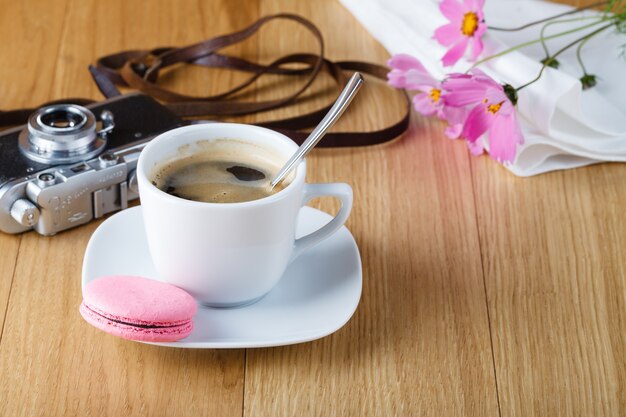 Desayuno con macarrón y cámara vintage en mesa