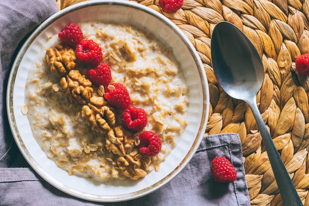 Desayuno de la mañana, avena en leche con frambuesas y nueces