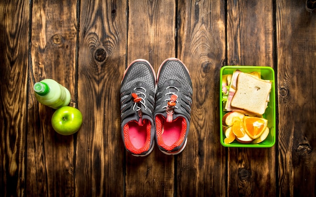 Desayuno en la mañana. Sándwiches, frutas, batidos y zapatillas deportivas