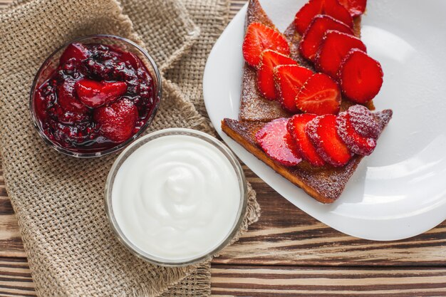 Desayuno de la mañana Tostadas con fresa y mermelada. Pan y confitura. Tostadas calientes frescas con crema. Delicioso postre casero.