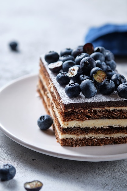 Desayuno matutino con café y tarta. Pedazo de pastel en un plato decorado con arándanos frescos