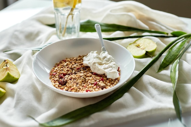 Desayuno matutino de granola con yogur griego y vaso de agua de desintoxicación