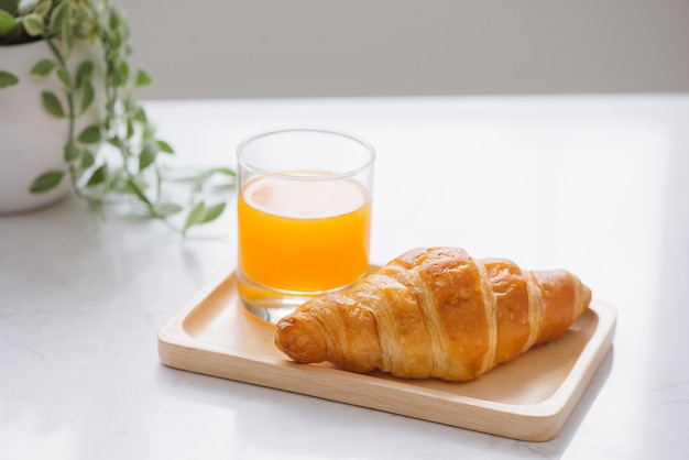 Desayuno matutino con jugo de naranja y pan en la mesa