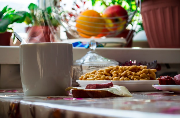 Desayuno matutino en el pueblo, té caliente al vapor sobre una taza de té.