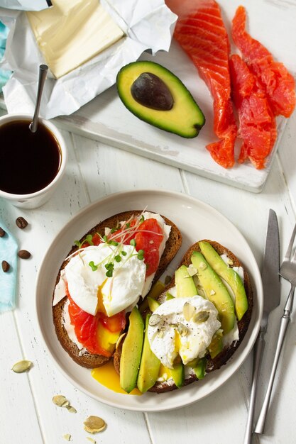 Desayuno matutino Sándwich de huevo escalfado con aguacate, salmón y café Vista superior