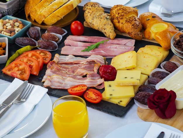 Desayuno en la mesa. El desayuno incluye pan de croissant, cereal de croissant, tocino, jamón, queso, lechuga, frijoles, hojuelas de maíz, fruta, café, té y jugo de naranja. Almuerzo o cena todos los días.