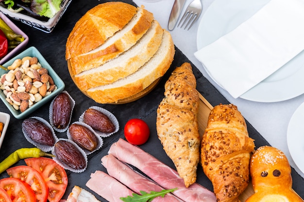 Desayuno en la mesa. El desayuno incluye pan de croissant, cereal de croissant, tocino, jamón, queso, lechuga, frijoles, hojuelas de maíz, fruta, café, té y jugo de naranja. Almuerzo o cena todos los días.