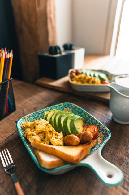 Desayuno en la mesa de madera en un plato de azulejos