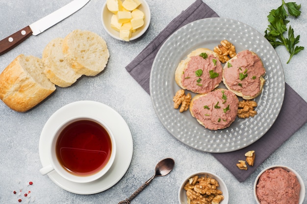 Desayuno en la mesa. Paté de pollo y sandwiches de mantequilla. taza de té