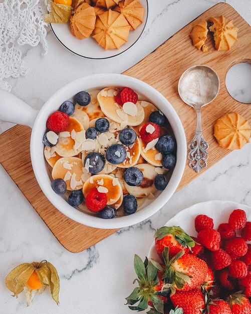 Desayuno, Mini crepes con fresas, croissants y aguacate, Deliciosa comida de verano, Vista superior sobre una espalda de mármol