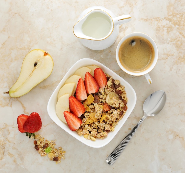 Desayuno con muesli, fresa y plátano.