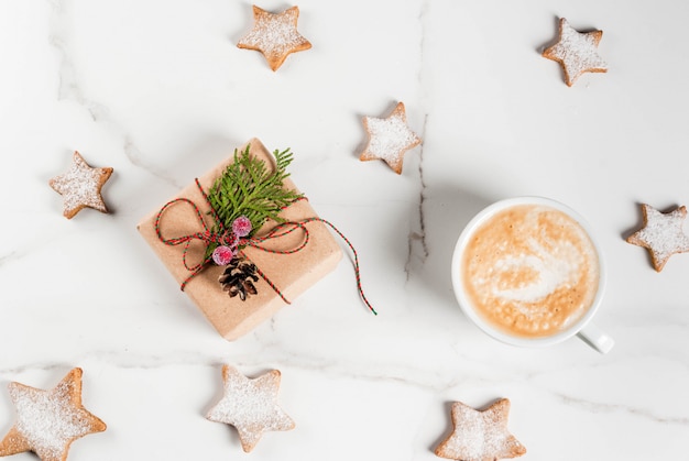 Desayuno de Navidad, taza de café con galletas de jengibre estrella, con regalo de Navidad o presente, en la mesa de madera blanca vista superior copyspace