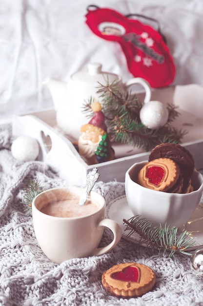Desayuno navideño en la cama con café y galletas.