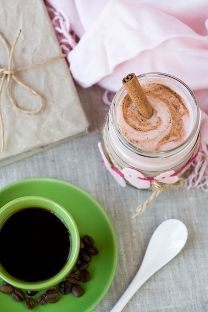 Desayuno nutritivo: avena con yogurt de bayas y canela, café negro y una botella de leche.