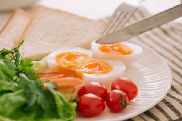 Desayuno o almuerzo saludable. Huevo poché con tomate y tostadas enteras. Enfoque selectivo. Alimentación saludable, concepto de estilo de vida saludable