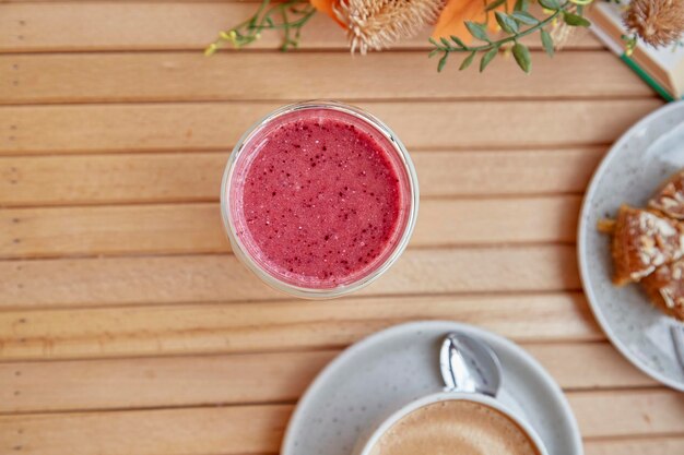 Desayuno de otoño saludable batido de fresa rosa en la mesa de madera