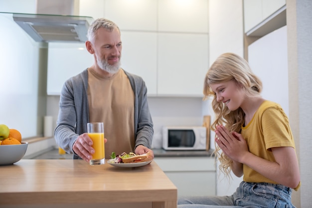 Desayuno. Un padre y una hija en la cocina desayunando.