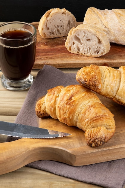 Desayuno con pan croissant salado y café.