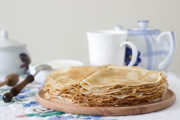 Desayuno panqueques servidos con crema agria y miel.