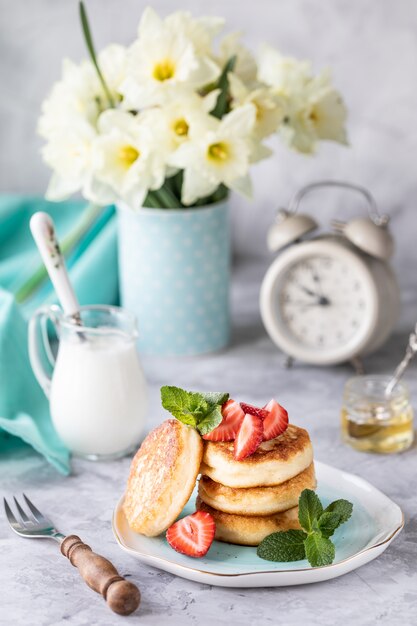 Desayuno de primavera con flores, tartas de queso y bayas frescas