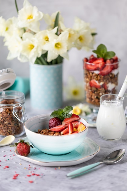 Desayuno de primavera con flores, tartas de queso y bayas frescas